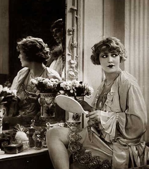 1920s beauty ritual with kohl-rimmed eyes and vintage vanity setup